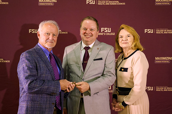 Arthur Clements, Dean Damon Andrew, and Patricia Clements pose with Arthur's Award