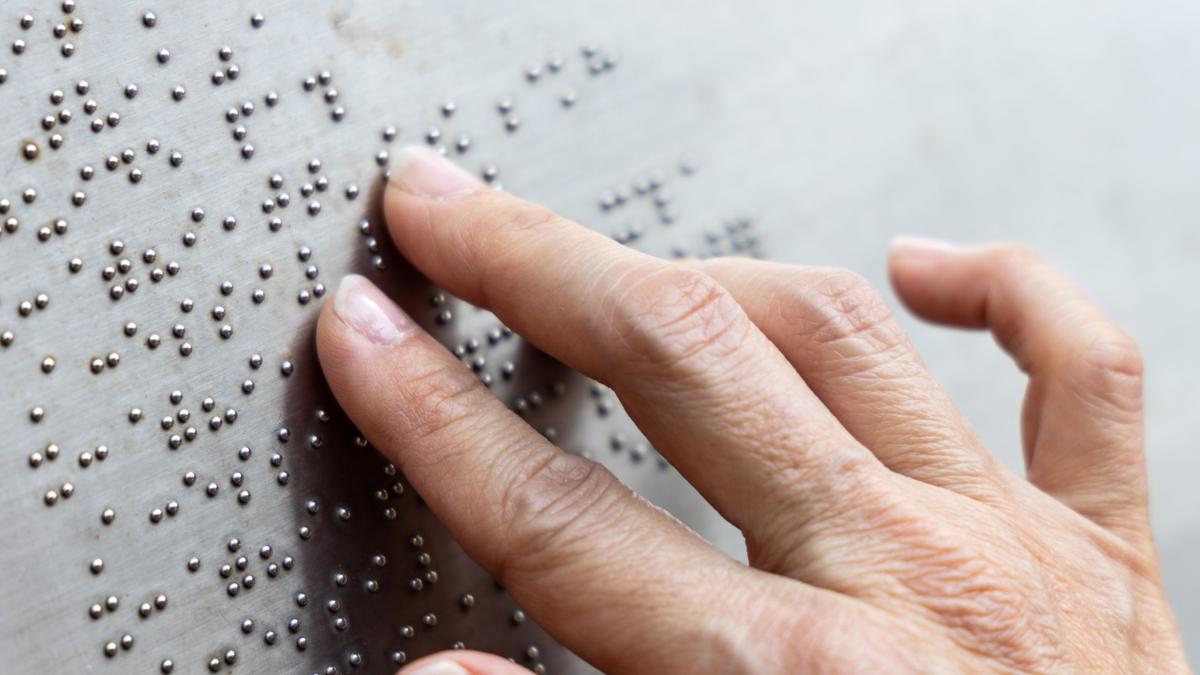close-up of hand reading braille