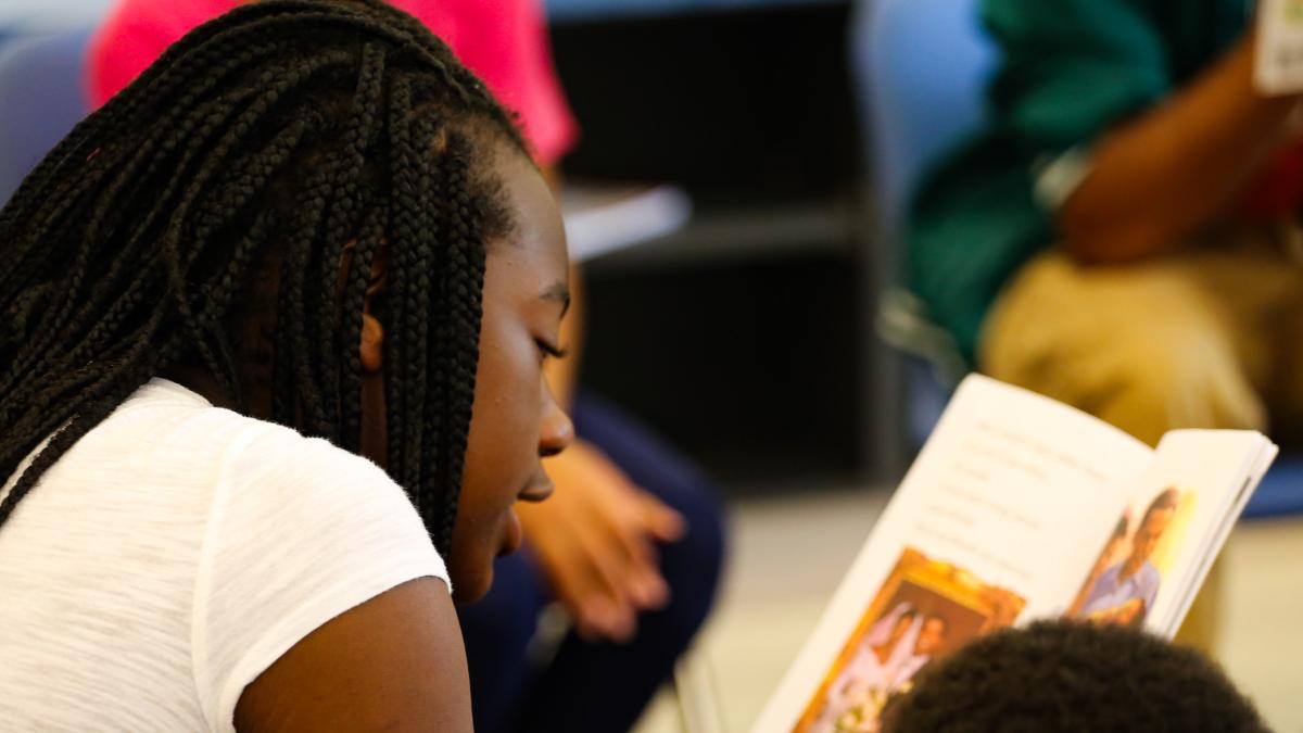 Student reading a book aloud
