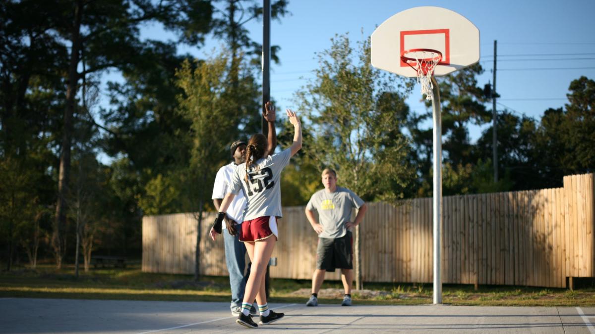 People playing basketball in a park