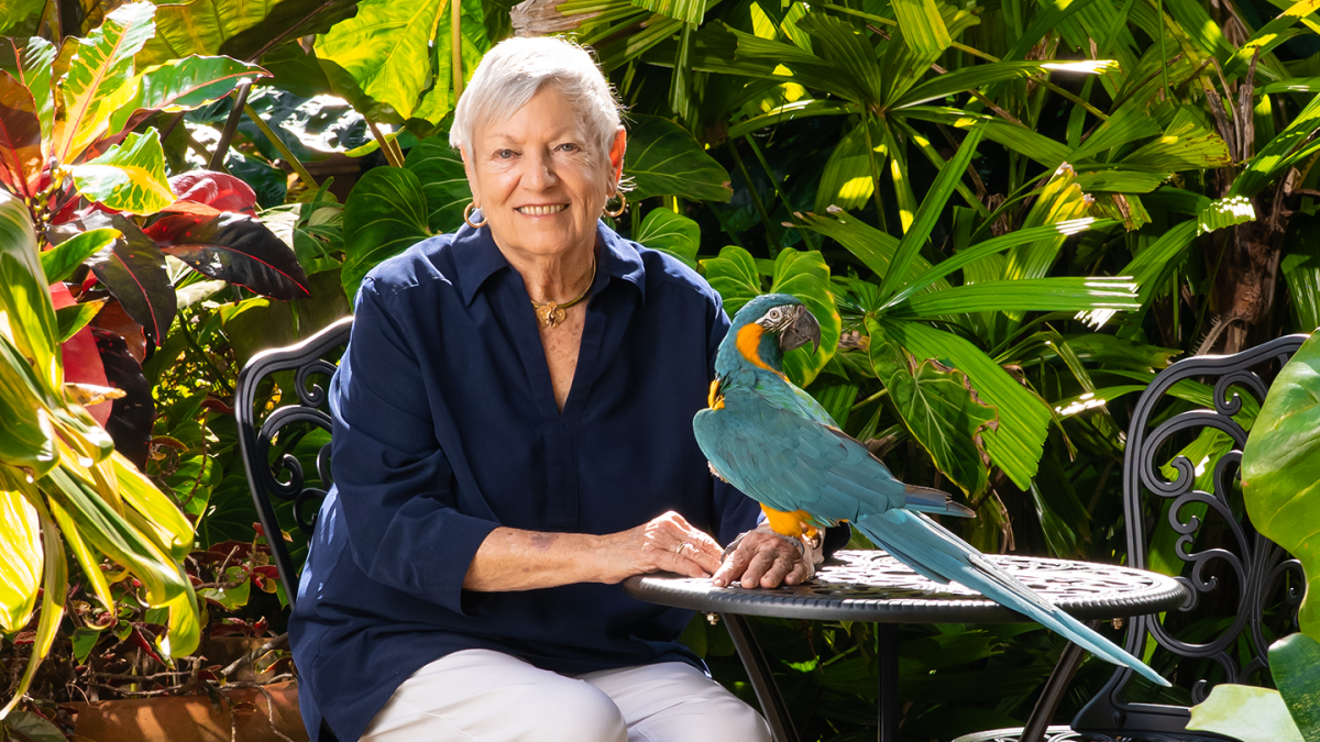 Sandy Shultz poses with a parrot