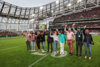 Anne's College Dean Damon Andrew and award-winning teachers are recognized on-field during a football game